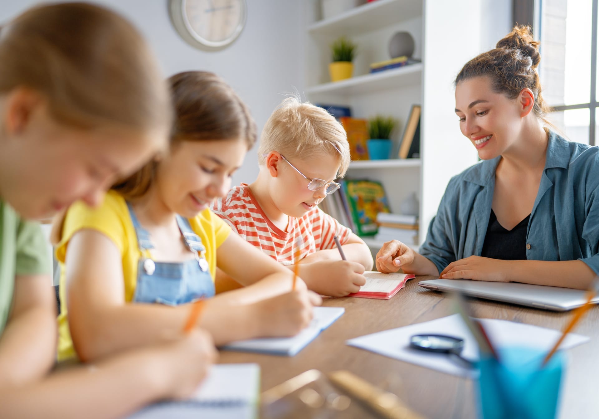 Homeschool mom teaching her children at the kitchen table with daily lesson guides